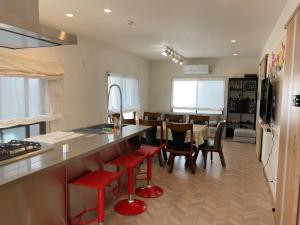 a kitchen and dining room with a counter and red stools at Platinum Yasaka in Kyoto