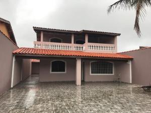 une maison avec un balcon et une cour dans l'établissement Casa de praia Caraguatatuba, à Caraguatatuba