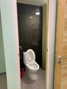 a bathroom with a white toilet in a stall at Beinte Singko de Marso Apartments in Candon