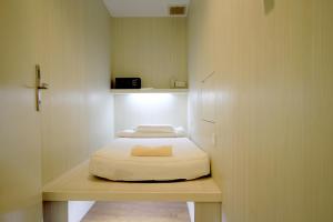 um pequeno quarto com uma cama sentada numa secretária em MP HOSTEL em Kuala Terengganu