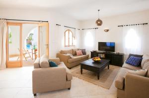 uma sala de estar com sofás e uma televisão em Red C Villas em Dahab