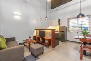 ein Wohnzimmer mit einem Sofa und einer Küche in der Unterkunft Phan NaTa Apartment in Siem Reap