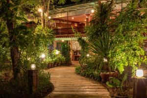 a walkway in a building with plants and lights at Baan Kitsada in Amphawa