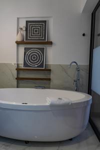 
a white bath tub sitting next to a white toilet at Agata Hotel Boutique & Spa in Mexico City

