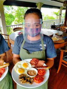 un hombre con un plato de huevos y otros alimentos en Anyar Estate, en Canggu