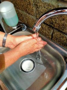 a person is washing their hands in a sink at Anyar Estate in Canggu