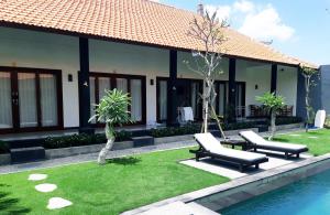 a house with two chairs and a swimming pool at Plawa Bali Guest House in Canggu