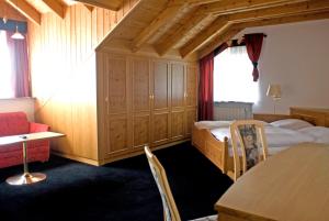 a hotel room with a bed and a table and chairs at Hotel Zum Fischerwirt in Baindlkirch