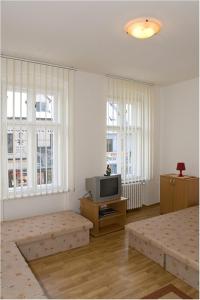 a living room with two beds and a television at Hyde Park Hostel in Bratislava