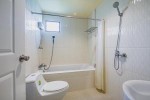 a bathroom with a toilet and a tub and a sink at Sakarin Valley Resort in Kanchanaburi