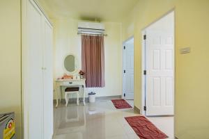 a white bathroom with a sink and a mirror at Sakarin Valley Resort in Kanchanaburi