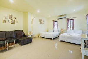 a large living room with two beds and a couch at Sakarin Valley Resort in Kanchanaburi