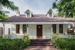 a white house with a brown door and stairs at Sakarin Valley Resort in Kanchanaburi +90 photos