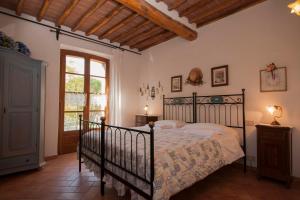 a bedroom with a black bed and a window at Agriturismo San Giorgio in Monteroni dʼArbia