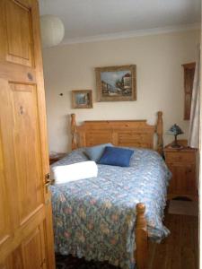 a bedroom with a bed with a blue comforter at Avebury Life in Avebury