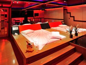 two beds in a room with red lighting at Motel Sunset (Adult Only) in Belo Horizonte