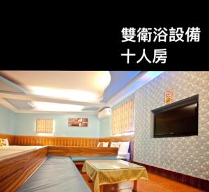 a room with a tv and a bed and a table at Bashi Channel Vacation B&B in Kenting