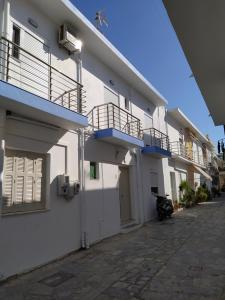 a white building with balconies on the side of it at F & P apartment in Kardamaina