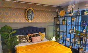 a bedroom with a bed with a blue head board at Portobella Airport Residence Self Check-In Aparthotel in Otopeni