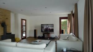 a living room with two white couches and a flat screen tv at Vakantiehuis - Rue du Château Deux in Voeren +13 photos