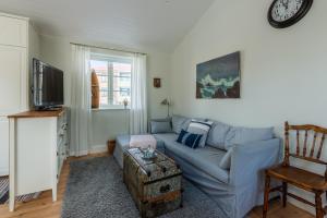 un soggiorno con divano blu e TV di Small Red House In Central Vaxholm a Vaxholm