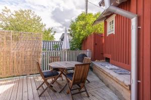 a wooden table and chairs on a wooden deck at Small Red House In Central Vaxholm in Vaxholm