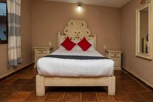 1 dormitorio con cama blanca y almohadas rojas en Hotel Rincon Soñado, Valle de Bravo en Valle de Bravo