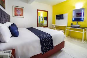 een slaapkamer met een groot wit bed en een televisie bij Hotel 522, Puerto Vallarta in Puerto Vallarta
