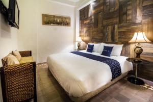 een slaapkamer met een groot bed en een stoel bij Hotel 522, Puerto Vallarta in Puerto Vallarta