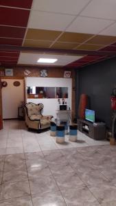 a living room with a couch and a television at Auberge bouloulou in Bouéni