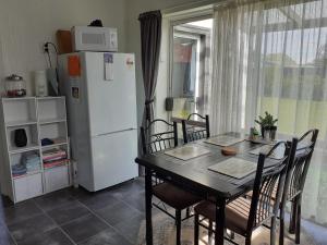 a kitchen with a table and a white refrigerator at Ellie's Villa in Brydone