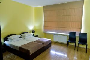 a bedroom with a bed and two chairs and a window at Imereti Health Resort in Tskaltubo