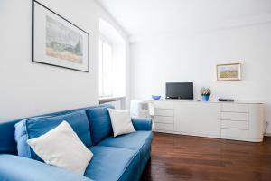 a living room with a blue couch and a tv at Downtown Como-Porta Torre Flat in Como