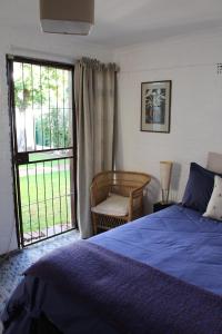 a bedroom with a bed and a large window at Delightful Surrey Street in Cape Town