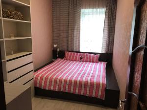 a small bedroom with a bed and a window at DAUGAVPILS in Daugavpils