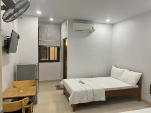 a small bedroom with a bed and a chair at Jasmine Mini Hotel in Hue