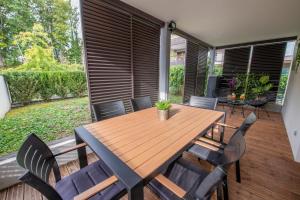 une table et des chaises en bois sur une terrasse dans l'établissement La Villa et sa plume, à Divonne-les-Bains