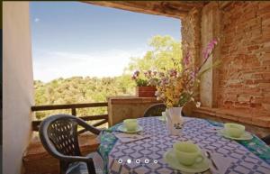 a table on a balcony with a vase of flowers at Quiete in San Dalmazio