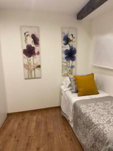 Un dormitorio con una cama y dos cuadros en la pared. en El Balcón de San Andres, en Cuenca