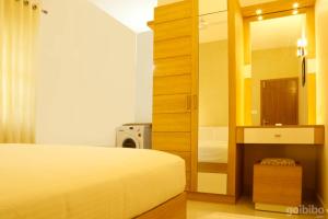 a bedroom with a bed and a bathroom with a mirror at Casa Allay in Cochin