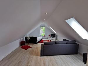 Una sala de estar con un sofá negro en un ático. en Apartment 1 Zimmer, en Walsrode