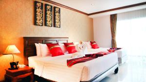 a hotel room with two beds and a lamp at Aiyaree Place Hotel SHA PLUS in Jomtien Beach