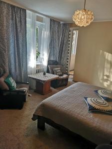 una camera da letto con un letto e un lampadario di Čiurlionio 83 Druskininkai a Druskininkai