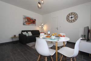 sala de estar con mesa blanca y sillas en L'Eden by EasyEscale en Romilly-sur-Seine