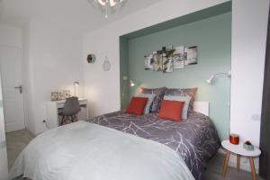una camera da letto con un letto grande con cuscini rossi di L'Eden by EasyEscale a Romilly-sur-Seine