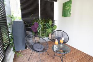 drie stoelen en een tafel op een terras met planten bij La Villa et sa plume in Divonne-les-Bains