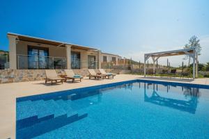 una piscina con sedie e una casa di Marianna Villas - Aria - ad Argostoli