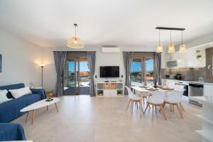 un soggiorno con divano blu, tavolo e sedie di Marianna Villas - Aria - ad Argostoli