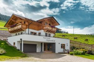 une maison avec un balcon au-dessus dans l'établissement Appartement Kufsteinblick, à Haus im Ennstal