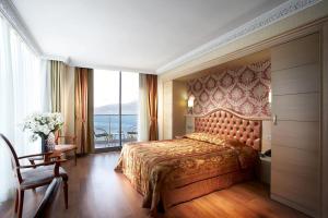 a bedroom with a bed and a large window at Emre Beach & Emre Hotel in Marmaris